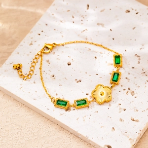 Gold stainless steel bracelet with rectangular emerald crystals and floral centerpiece charm