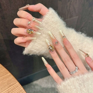 Sparkling stiletto press-on nails with champagne rhinestones and golden butterfly accents