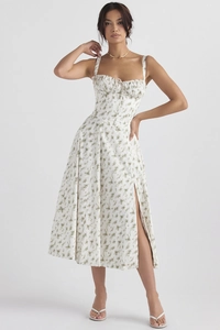 Detail van witte midi-jurk met bloemenprint, vierkante hals met strik en hoge zijsplit