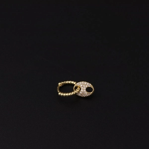 Detailed view of a gold-plated hoop earring featuring a pavé zircon oval pendant on black