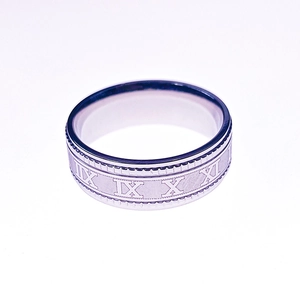 Macro shot of silver stainless steel band featuring engraved Roman numerals on the surface
