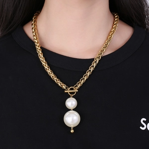 Detail einer klobigen Goldkette mit Doppelperlen und Knebelverschluss am Modell