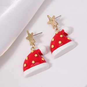 Detail of red Christmas hat earrings with gold star studs on white silk background