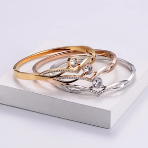 Polished V-shaped titanium bracelets in gold, silver, and rose gold with zircon stones