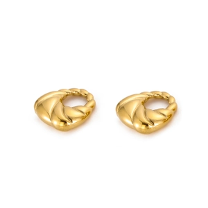 Detail of gold heart earrings with twisted texture and polished metallic finish
