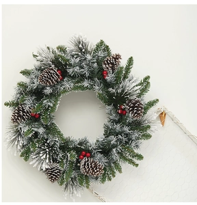 Close-up of premium Christmas wreath with realistic pine needles, snow, cones and red berries