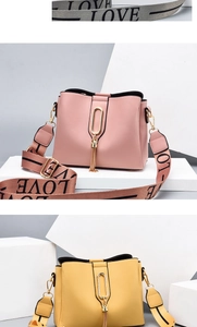 Detail of pink and yellow bucket bags with wide printed strap and tassel charms