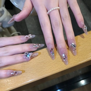 Faux ongles longs en amande rose nude avec paillettes et strass étincelants