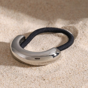Detail of high-elastic black hair tie with polished silver metallic C-shaped accent