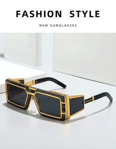 Detail of cyber sunglasses with gold metal frame and black lenses on white background