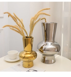 Detail view of modern silver and gold electroplated ceramic vases in home interior