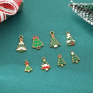 Detail of assorted enamel Christmas tree and snow house charms in red, green and gold colors