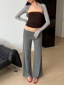 Détails du tricot du pantalon évasé gris et du haut bandeau marron avec liseré orange