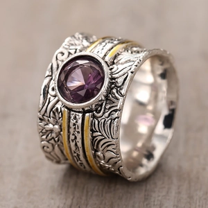 Vintage wide band ring featuring purple gemstone and intricate floral relief engraving