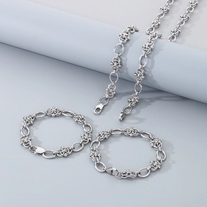 Detailed close-up of silver titanium steel necklace and bracelets on gray pedestals