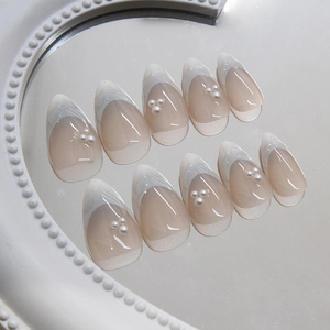 Elegant French press-on nails with white tips, 3D pearls, and glossy nude finish