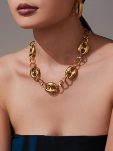 Détail du collier à maillons grain de café creux et boucles d'oreilles dorées sur modèle