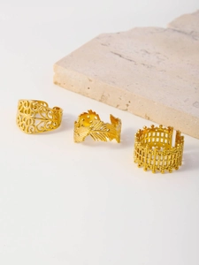 Detail of three gold mesh rings with floral, feather and architectural textures on stones