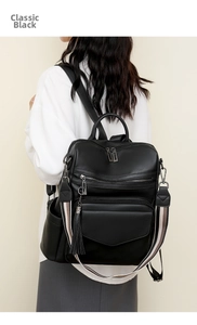 Detail view of retro black backpack with fringe tassel and striped fabric shoulder strap