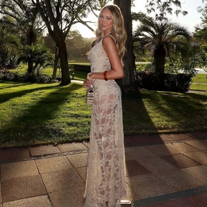 Side view of a sexy beige lace maxi dress with draped neck and backless detail