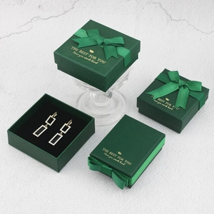 Dark green jewelry gift box set with bow ribbon and gold geometric earrings display
