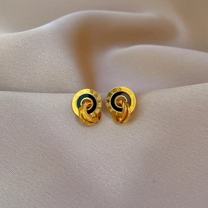 Detail of titanium steel Roman numeral earrings in gold and black with a luxury finish