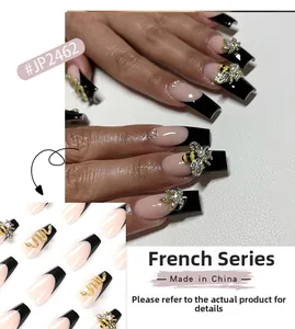 Detail of long coffin nails featuring black French tips, 3D bees, snakes, and crystal leaves