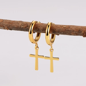 Gold stainless steel hoop earrings with hanging cross charm on a natural branch