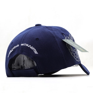 Detail of dark blue tactical baseball cap featuring white embroidery and adjustable strap