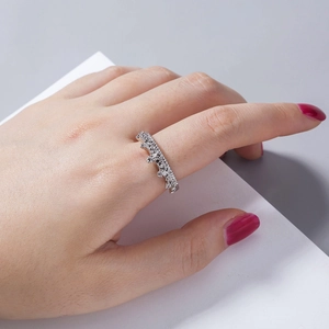 Detailed close-up of a silver crown ring with zircon stones worn by a hand model