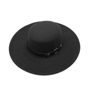 Detail view of a black flat top hat featuring a leather band with gold metal studs