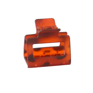 Detail of square amber resin claw clip with metal spring and tortoiseshell texture