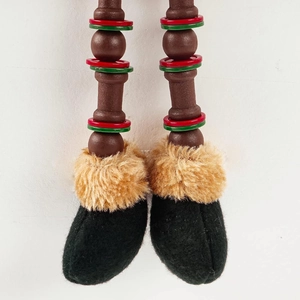 Detail of wooden doll legs with red and green rings and faux fur boots for Christmas décor