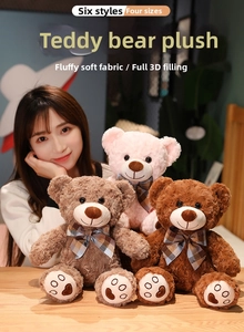 Close-up of cute plush teddy bears in three colors with plaid bows and embroidered paw prints