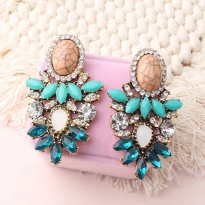 Detailed macro view of bohemian flower drop earrings with colorful crystals and rhinestones