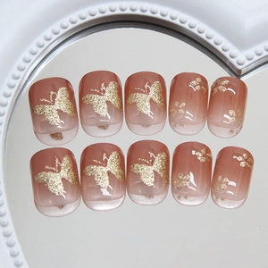Pink gradient square press-on nails with golden glitter butterflies and floral accents