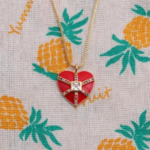 Vue détaillée du pendentif coeur en émail rouge avec des zircons multicolores