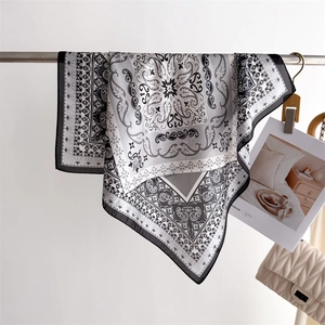 Detail of paisley printed silk scarf showing elegant drape and smooth satin texture