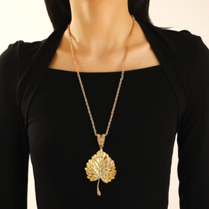 Chic gold maple leaf pendant necklace with sparkling crystals on a long sweater chain