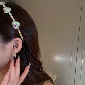 Detailed view of a gold headband with heart stones and matching floral earrings