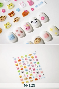 Detail view of M-129 cartoon animal nail stickers with pandas and rabbits on white nails