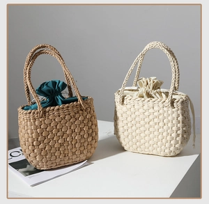 Vue détaillée de sacs à main en paille tressée en marron et beige avec doublure à cordon
