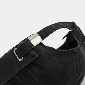 Detail of adjustable metal slider buckle and washed cotton texture on black beanie