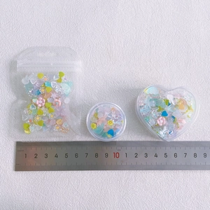 DIY nail art charms kit with colorful beads, flowers and bows in assorted storage containers