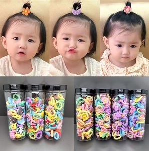 Detail showing elastic hair ties for toddlers in a clear jar and on a child model