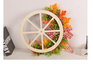 Close-up of wooden wagon wheel wreath with maple leaves and red plaid ribbon bow