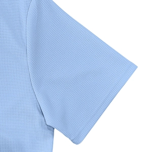 Detalle macro de la textura del tejido de punto gofrado azul claro y costura del polo hombre