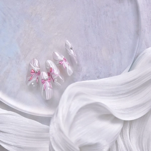 Détails de nœuds 3D roses et perles sur ongles adhésifs blancs forme amande