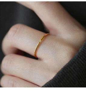 Macro shot of a thin gold titanium ring featuring a single micro zircon stone inlay