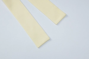 Detail view of the fine stitching and texture on the pale yellow fabric waist belt